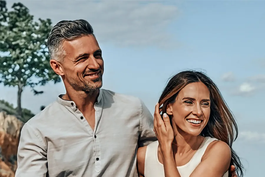 A middle-aged couple walking outside on a sunny day smiling after receiving expert BPC-157 Peptide Therapy by Don D. Fisher, D.O. at The BEST Program in Fort Lauderdale.
