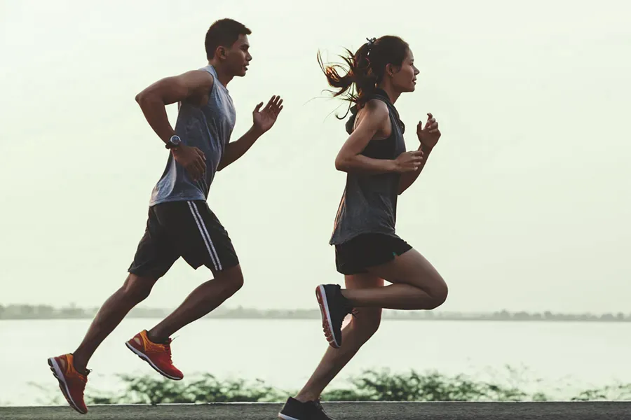 A couple in profile running along the water. Schedule GLP-1 Weight Loss Injections from Don D. Fisher, D.O. at The BEST Program in Fort Lauderdale.