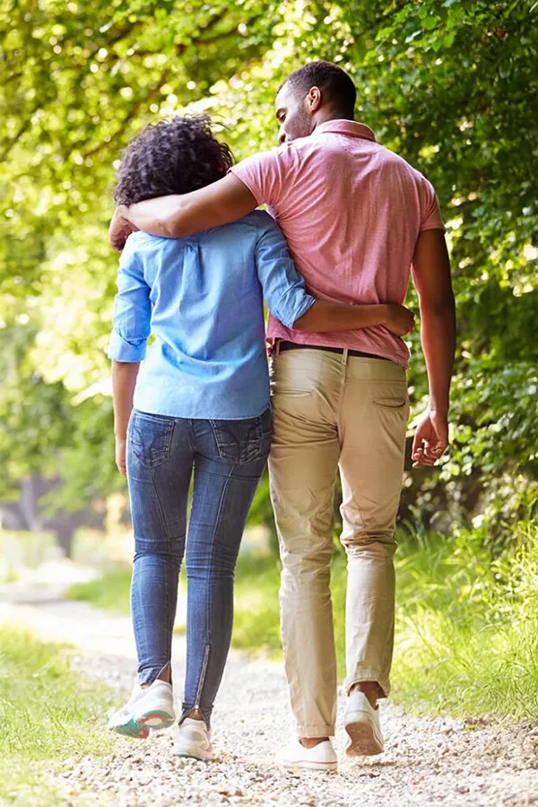 A healthy black couple take a nice stroll on a trail. Get MOTS-c Peptides for metabolism and weight loss from Don D. Fisher, D.O. at The BEST Program in Fort Lauderdale.