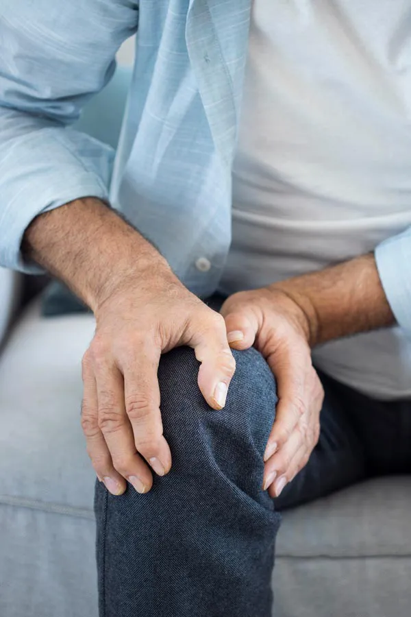 A close-up of a man holding his knee while experiencing pain from osteoporosis. Get osteoporosis treatment from Don D. Fisher, D.O. at The BEST Program in Fort Lauderdale.