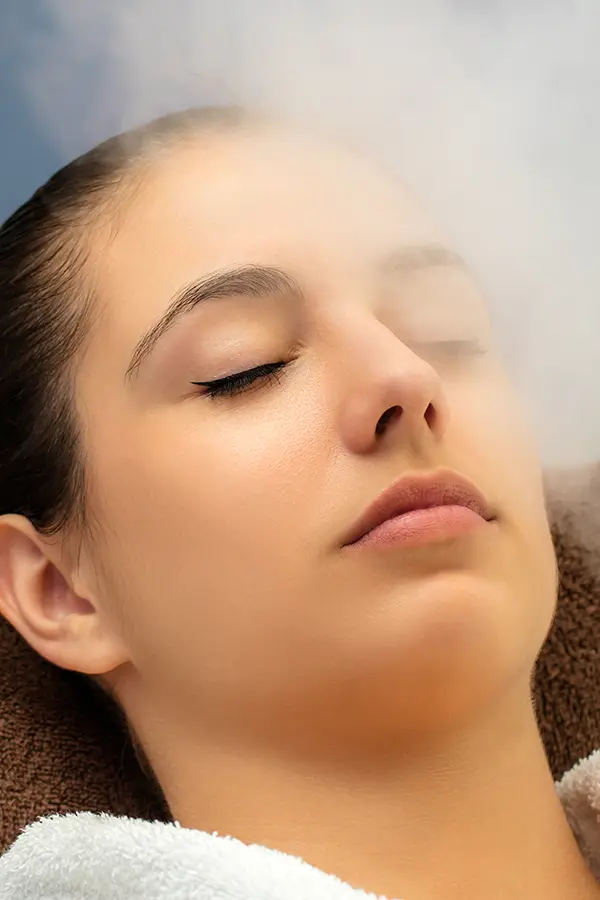 Close-up of a woman with her eyes closed breathing in mist. Get ozone therapy from Don D. Fisher, D.O. at The BEST Program in Fort Lauderdale.