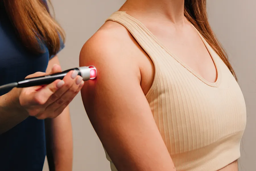 A woman receives cold laser therapy on her shoulder. Schedule photobiomodulation therapy from Don D. Fisher, D.O. at The BEST Program in Fort Lauderdale.