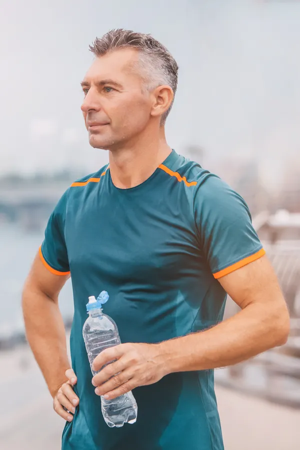 A middle-aged man rehydrates after a hard workout. Get plaquex IV therapy from Don D. Fisher, D.O. at The BEST Program in Fort Lauderdale.