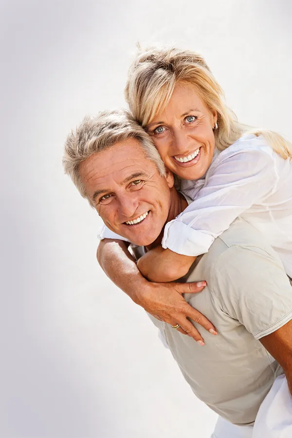 A mature couple smiling as the husband holds the wife on his back. Get plasma pen treatment for skin from Don D. Fisher, D.O. at The BEST Program in Fort Lauderdale.