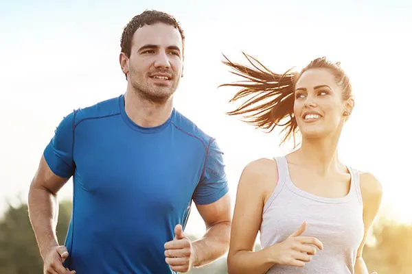 A couple happily jogging in the sunlight after receiving effective weight loss resistance care from Don D. Fisher, D.O. at The BEST Program in Fort Lauderdale.